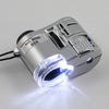 Silver handheld magnifier with a UV light and storage pouch, showing a bright beam of light.