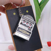 A silver mini fruit slot machine keychain fidget toy attached to a wooden board.