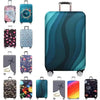 A collection of various colored and patterned suitcase protector covers displayed in a row.
