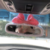 Pink bow shaped plush bear and pig car rearview mirror covers inside a vehicle
