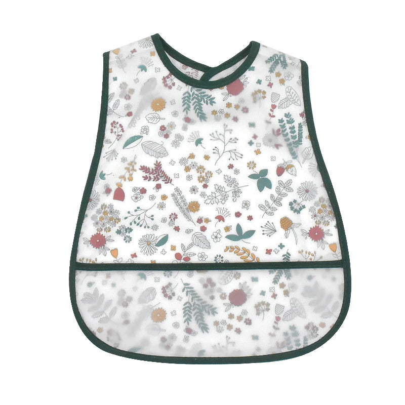 A white baby feeding bib with a dark green trim featuring a floral and leaf pattern.