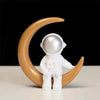 A handcrafted astronaut figurine resin spaceman desk decor against a black background.