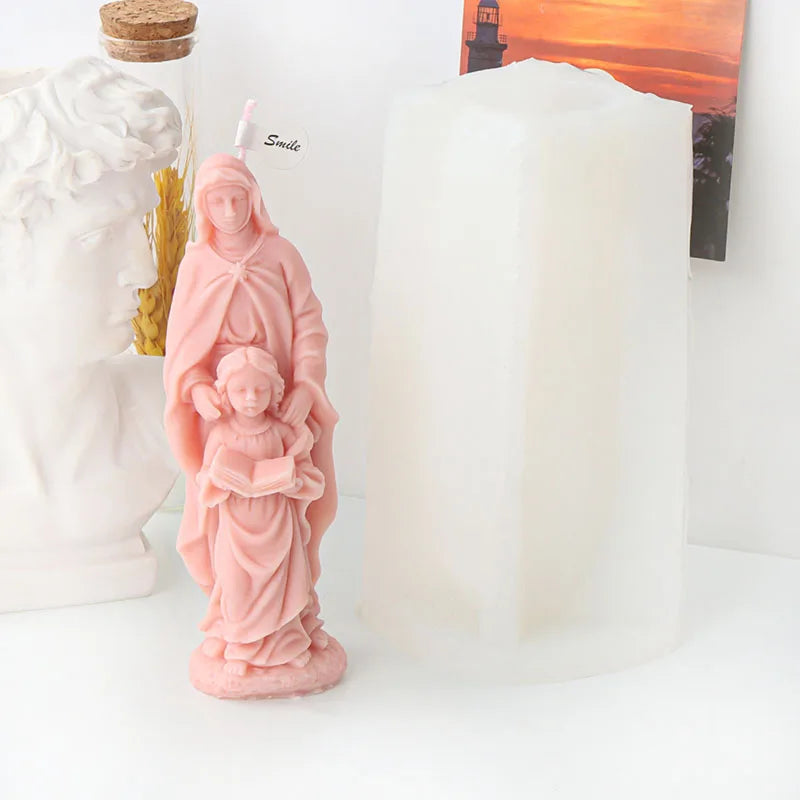 A pink silicone mold shaped like the Virgin Mary holding the infant Jesus for candle and resin crafting.