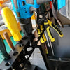 A close-up view of a black wall-mounted tool organizer holding various hand tools like pliers and screwdrivers.