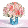 A bouquet of pink and peach roses and cherry blossoms arranged in a blue vase
