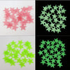 A set of 100 luminous star wall stickers for a kids' room, shown in pink and green colors.