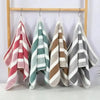 A set of striped microfiber towels hanging on a wooden rack.