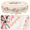 Vintage floral tablecloth with pink and blue roses and greenery on a round dining table.