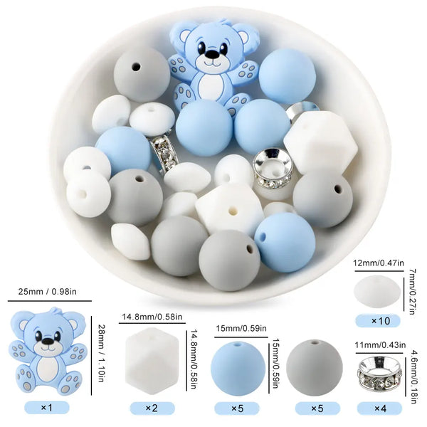 Un plato blanco lleno de cuentas focales de silicona en tonos azul claro y blanco para hacer joyería