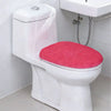A white toilet with a bright pink flannel seat cover installed on it.