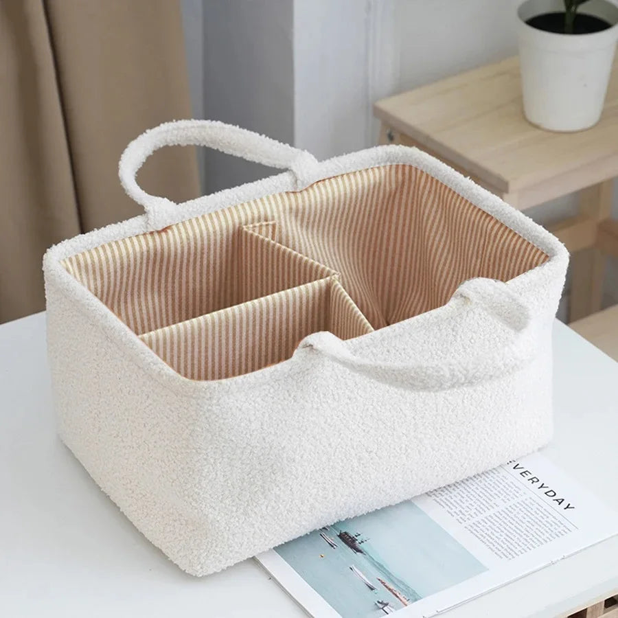 A white, fluffy portable diaper bag organizer with a lid and divided compartments for storing bottles or items.