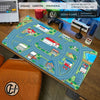 A large gaming mouse pad featuring a vintage city road design with buildings and greenery on a wooden desk.