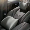 Interior view of a car seat showing memory foam headrest and lumbar support pillows on the driver's seat.