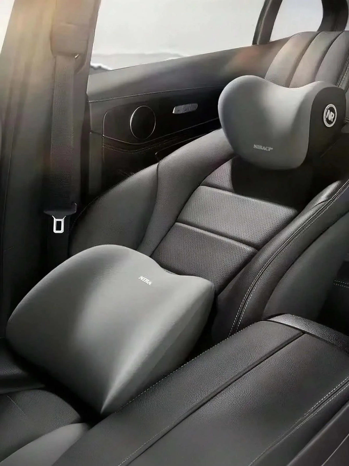 Interior view of a car seat showing memory foam headrest and lumbar support pillows on the driver's seat.
