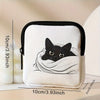 A white mini coin purse featuring a black cat sleeping inside a white fabric lining.