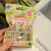 A hand holds a Sylvanian Families Mini Party Babies set featuring various collectible figures.