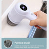 A hand is using a white pointed brush on a drain or washbasin to clean corners and crevices.