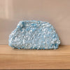 A light blue sequin beaded chain shoulder clutch bag resting on a wooden surface.