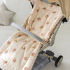 A beige and pink cartoon bear stroller cushion is shown in a light-colored stroller seat.