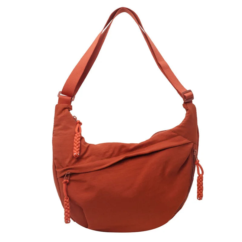 A terracotta orange lightweight nylon crossbody bag with adjustable strap.