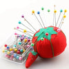 A red fabric ball head decorated with various colored pearlized ball pins sticking out.