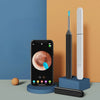 An HD visual ear cleaner device with a camera and LED light is displayed on a blue stand.