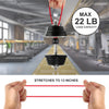 A hand holds a red bungee cord attached to a weight, demonstrating the stretch capability of heavy-duty ball bungee cords.