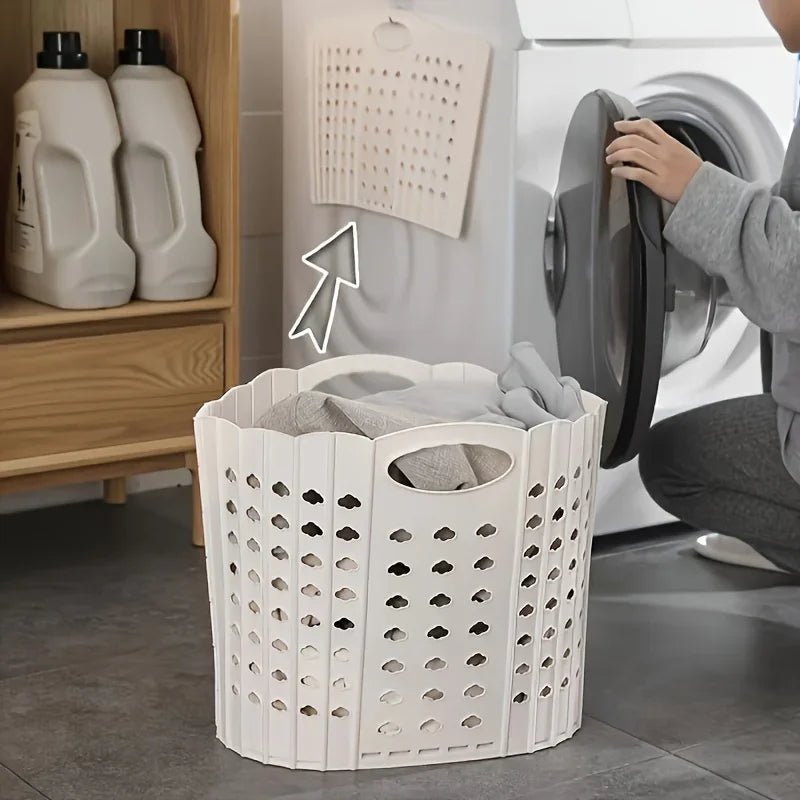 A white folding laundry basket with handles is shown next to a washing machine.