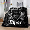 A black throw blanket featuring portraits of Eminem and Tupac with text on the fabric.