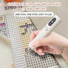 A hand holds a white electric diamond art pen with a vacuum suction feature, demonstrating its use on a grid surface.