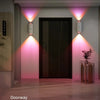 Interior doorway featuring modern wall lights illuminating a dark door and wooden floor.