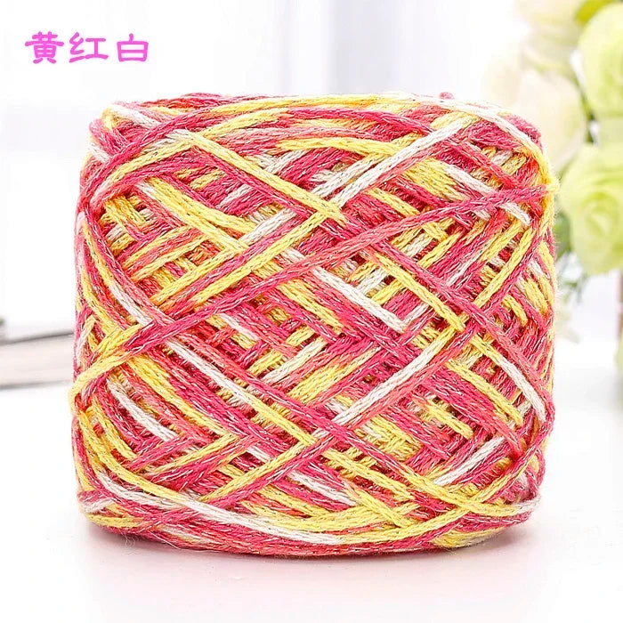 A ball of pink and yellow metallic silk crochet yarn used for knitting and macrame