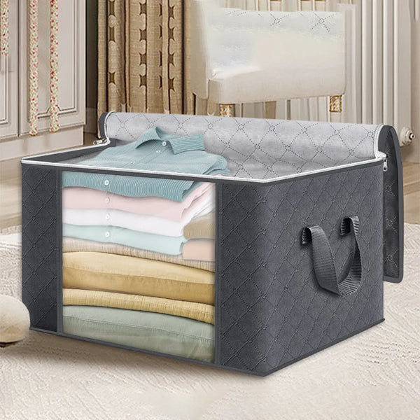 Bolsa de almacenamiento gris plegable con ventana transparente, abierta mostrando ropa doblada en azul claro y beige.