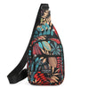 A black sling crossbody bag featuring a colorful leaf print design with multiple zippered pockets.
