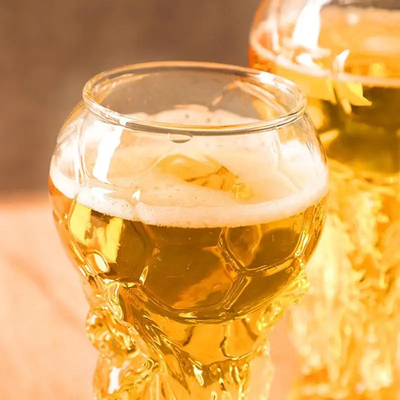 Nahaufnahme eines goldenen Bieres in einem trophäenförmigen Glas mit Schaumkrone.