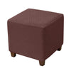 A square ottoman slipcover in a deep reddish-brown color with a textured diamond pattern.