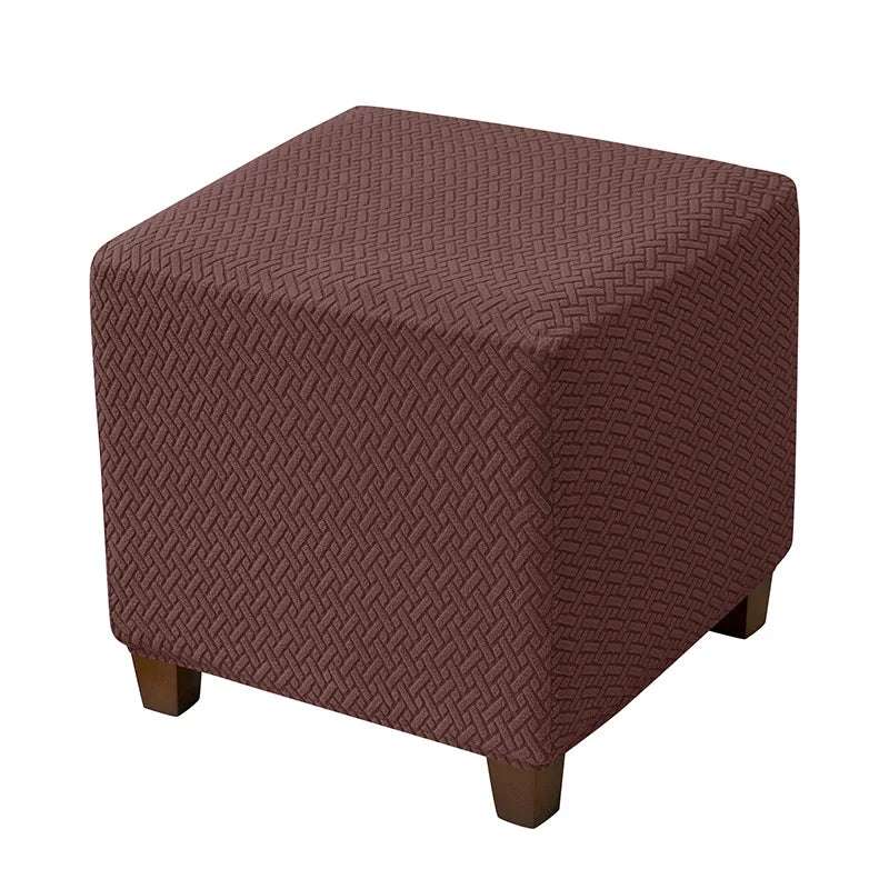 A square ottoman slipcover in a deep reddish-brown color with a textured diamond pattern.