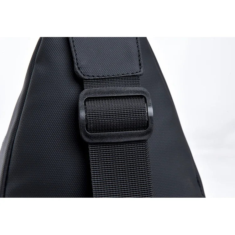 Black men's adjustable crossbody chest bag with a textured strap shown from the side.