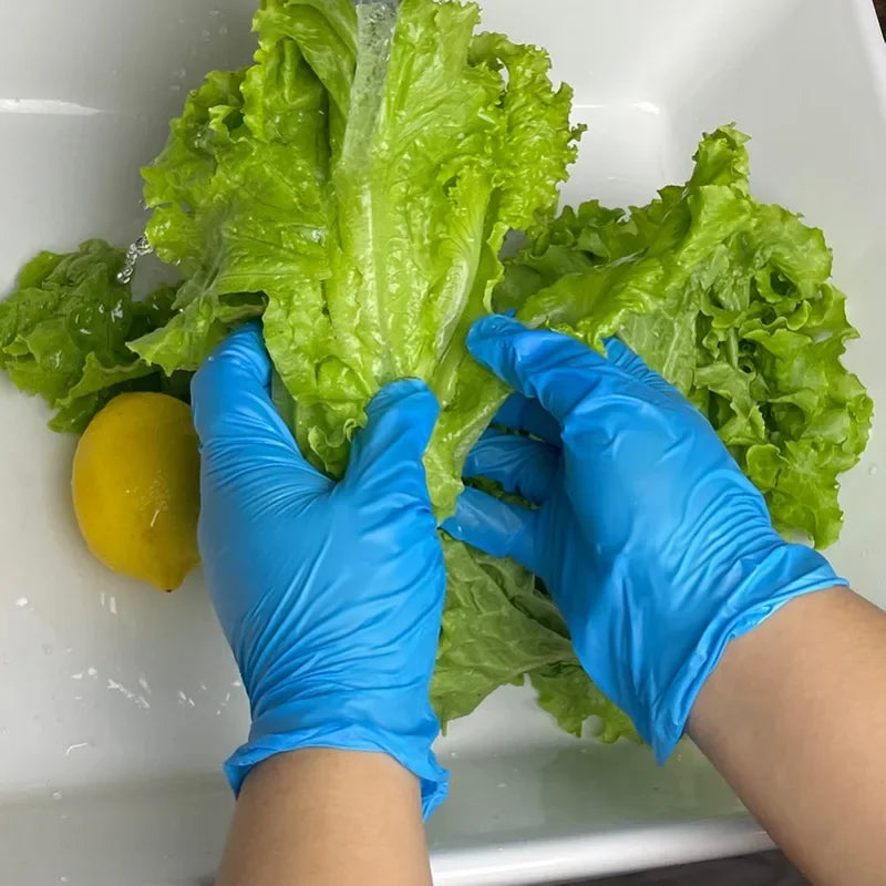 A person wearing blue nitrile gloves is handling a head of green lettuce in a white bowl.
