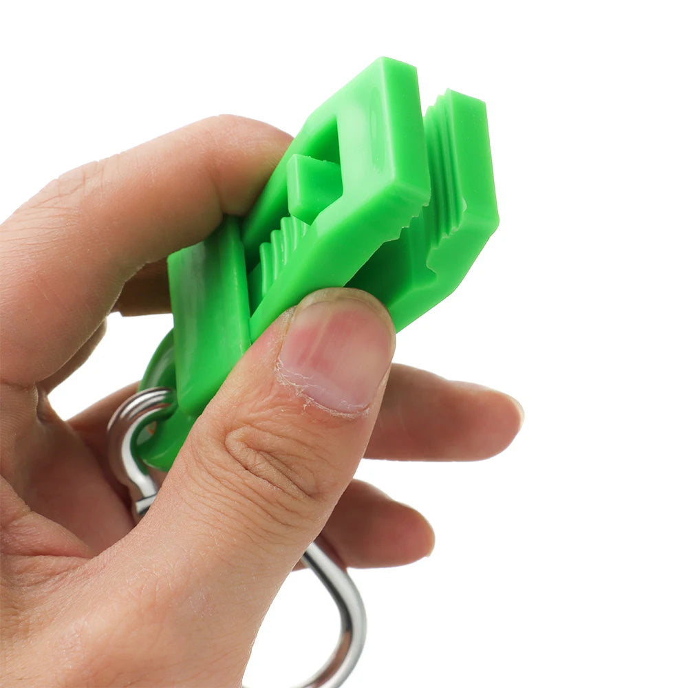 A hand is holding a bright green durable glove clip with an ergonomic grip.