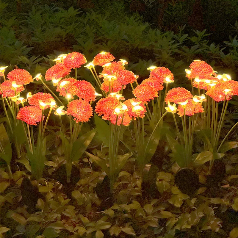 Row of orange glowing bee lights illuminating green foliage in a garden at night