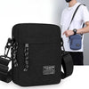 Black mini crossbody phone bag with adjustable strap worn by a person.