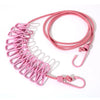 Pink elastic travel clothesline with non-slip clips coiled on a white background