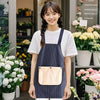 A young woman models a navy blue striped waterproof kitchen apron with a removable beige towel.