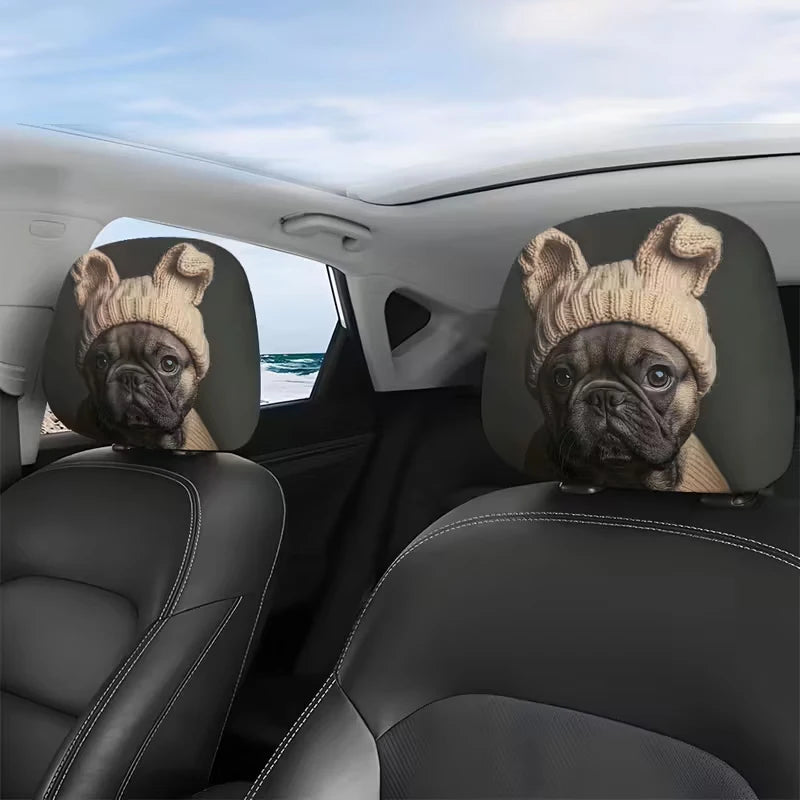 A pair of dog-eared headrest covers featuring pug faces are placed on the front seats of a car interior.