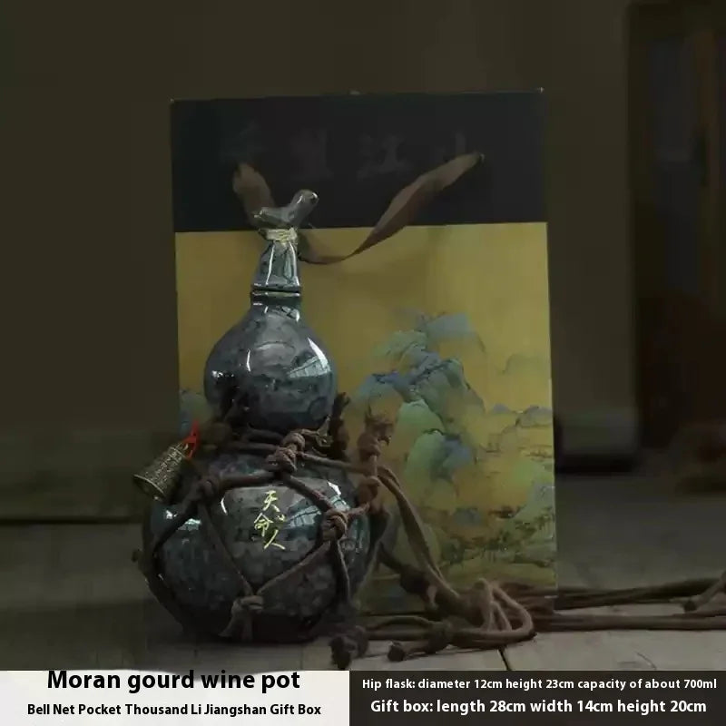 A handcrafted ceramic gourd wine set featuring a dark glass bottle and a net bag, presented in a gift box.