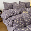 A set of soft printed duvet covers and pillowcases in a gray fabric with a small floral pattern.