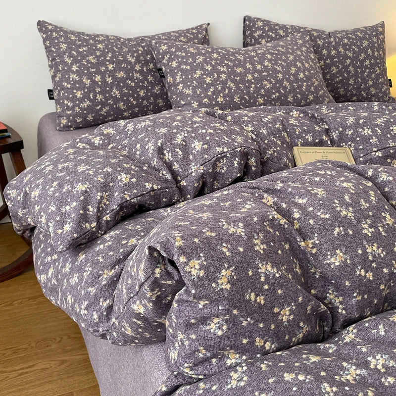 A set of soft printed duvet covers and pillowcases in a gray fabric with a small floral pattern.