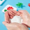 Hands holding white craft powder and colorful plastic sea creatures on a blue background
