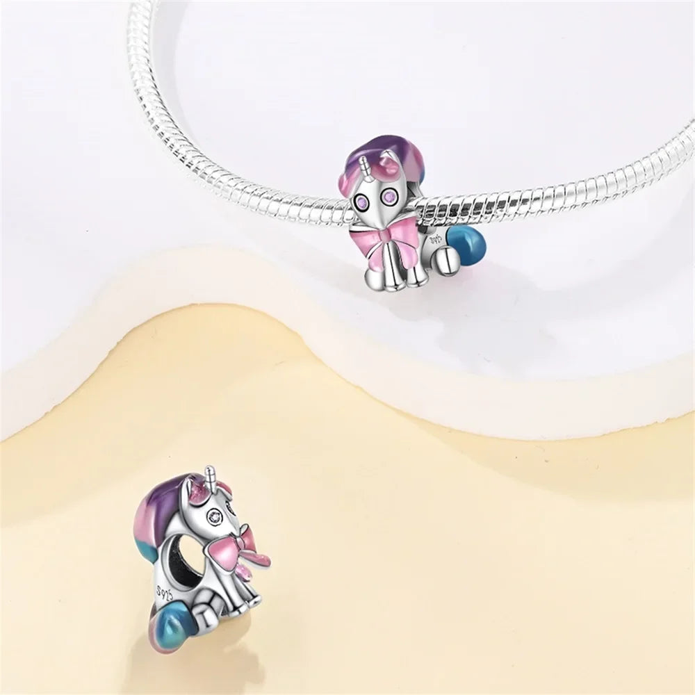 Silver unicorn charm with purple and blue accents attached to a silver chain.